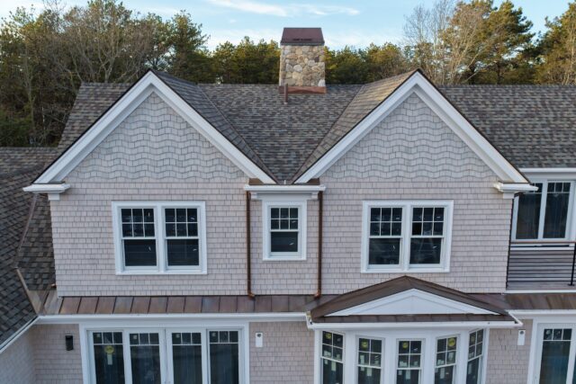 Natural white cedar siding with woven corners and stone chimney detail